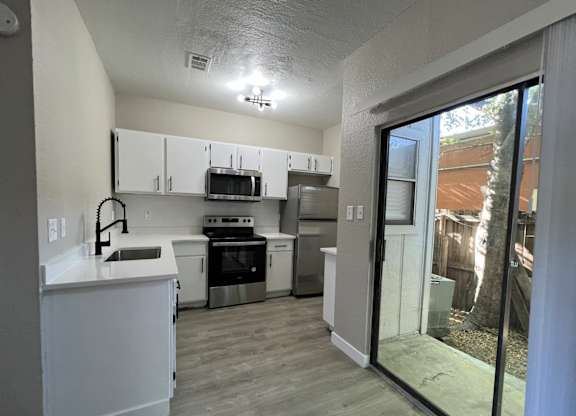 A kitchen with white cabinets and appliances.