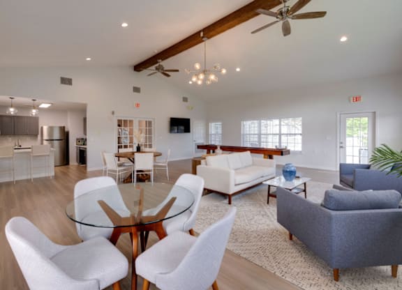 A modern living room with a glass table surrounded by white chairs at Retreat at Savannah Apartments, Georgia, 31404