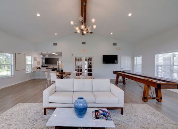 A spacious living room with a white sofa and a pool table at Retreat at Savannah Apartments, Savannah 31404