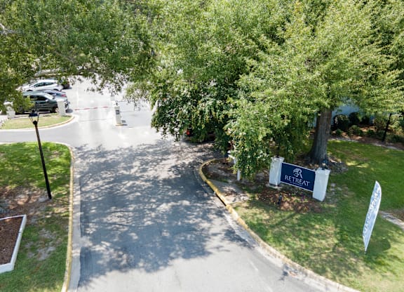 A sign that says Retreat stands in front of a tree at Retreat at Savannah Apartments, Georgia