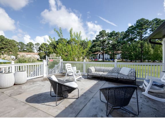 A patio with a white chair and a black chair at Retreat at Savannah Apartments, Savannah