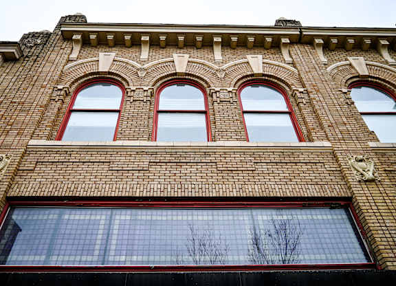 A red brick building with three arched windows.