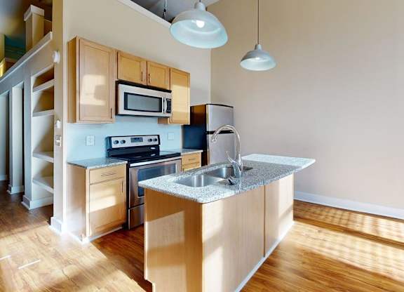 A kitchen with wooden cabinets and a stainless steel sink.
