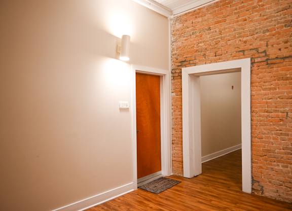A room with a brick wall and a wooden floor.