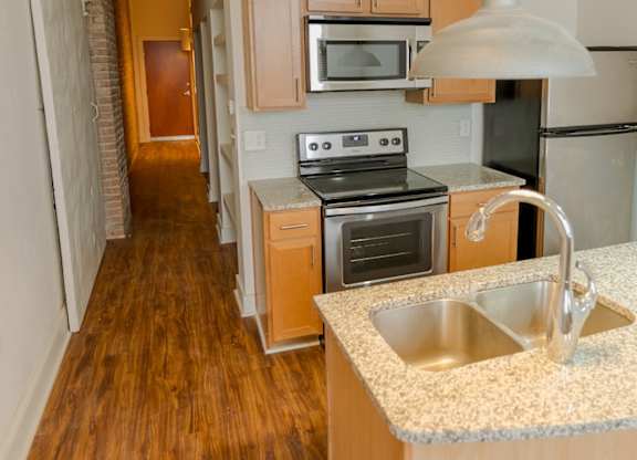 A kitchen with wooden cabinets and a stove top oven.