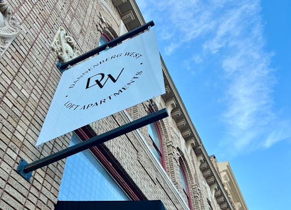 A sign for a vacation rental is hanging from a building.