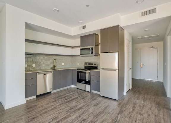 A kitchen with a refrigerator, oven, and microwave.at Catalina West Adams, Los Angeles, 90016