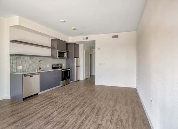 A kitchen with a refrigerator, oven, and microwave.at Catalina West Adams, Los Angeles