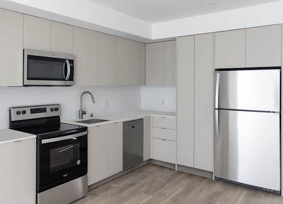 A modern kitchen with a stainless steel refrigerator, oven, and microwave.at The Wilson, Santa Monica, 90405