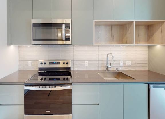 A modern kitchen with a stove, microwave, and refrigerator.at The Dillon II at Silver Lake, California, 90026