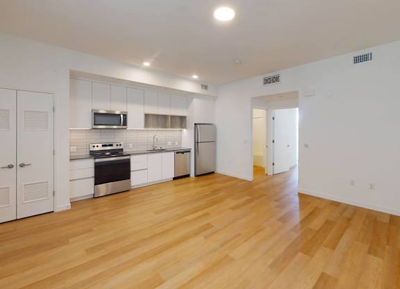 A kitchen with white cabinets and a wooden floor.at The Dillon II at Silver Lake, California