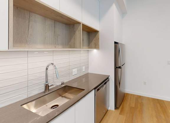 A kitchen with a sink and a refrigerator.at The Dillon II at Silver Lake, Los Angeles California