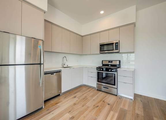 A modern kitchen with a stainless steel refrigerator and a stainless steel oven.at 5135 W Adams, California, 90016