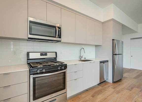A modern kitchen with a stove, oven, microwave, and refrigerator.at 5135 W Adams, Los Angeles, 90016