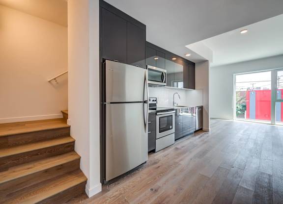 A modern kitchen with a refrigerator, microwave, and oven.at 5263 W Adams, Los Angeles, 90016