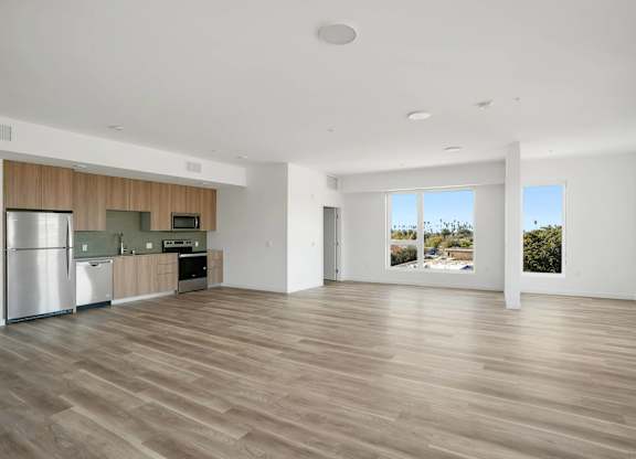A spacious kitchen with wooden floors and a refrigerator.at 2221 S Western, Los Angeles California