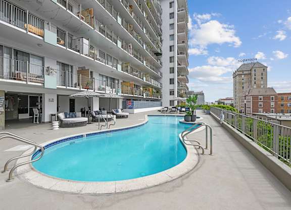 A swimming pool is located on the balcony of a building.