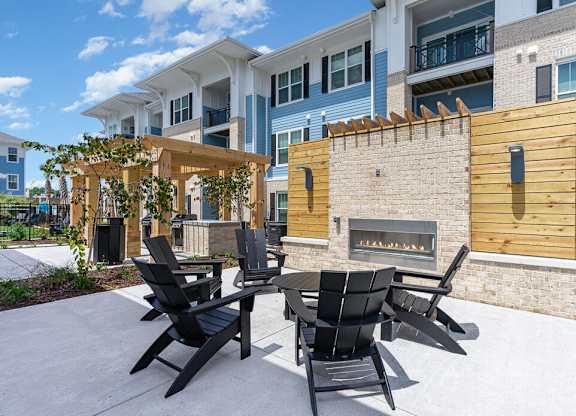 A patio with a fireplace and chairs at The Banks at Bridgewater Apartments, South Carolina, 29566