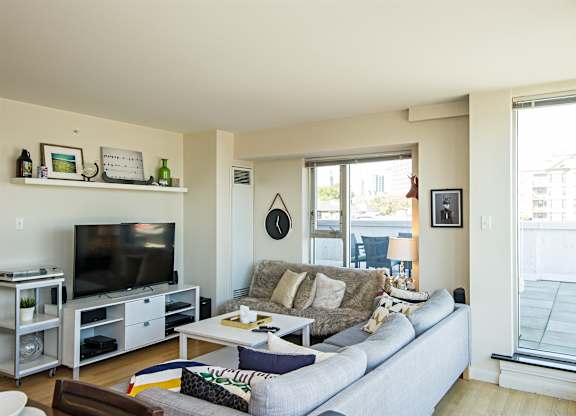 A living room with a grey couch and a television.