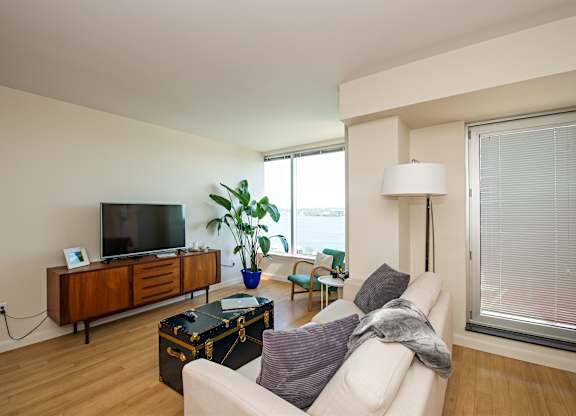 A living room with a white couch and a wooden cabinet.