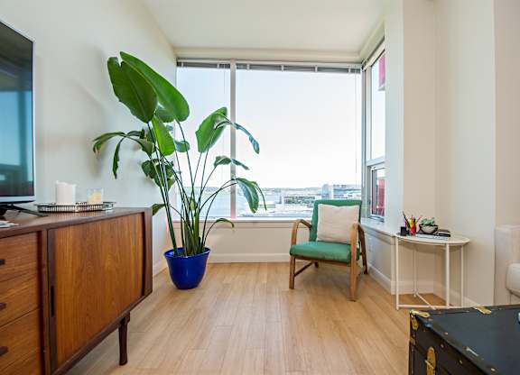 A room with a green chair and a blue pot.