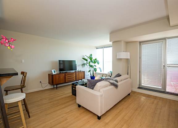 A living room with a white couch and a wooden entertainment center.