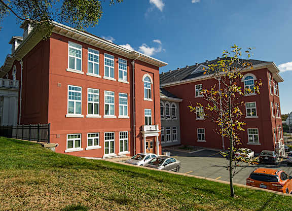 A red building with a tree in front of it.