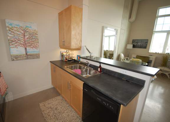 A kitchen with a black counter top and wooden cabinets.
