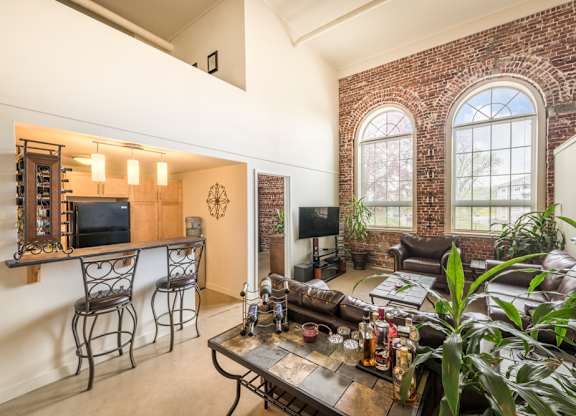 A living room with a brick wall and a large window.
