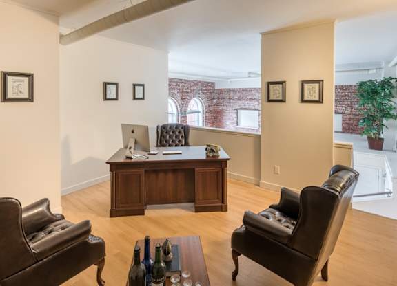 A living room with a brown leather chair and a wooden table.