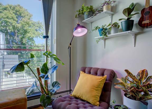 A room with a purple chair and a yellow pillow.