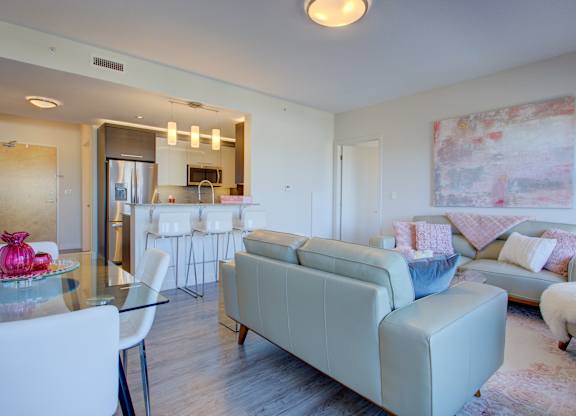 A modern living room with a glass table and white chairs.