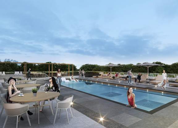 A group of people are enjoying a sunny day by the pool and dining tables.
