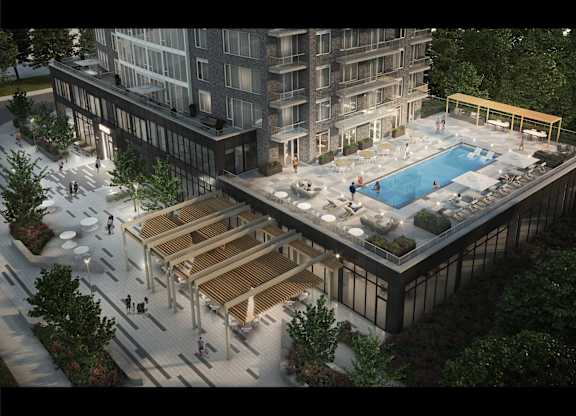 A modern building with a pool and a wooden deck.