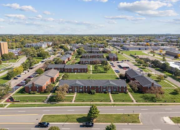 A large building complex with a green lawn in front.