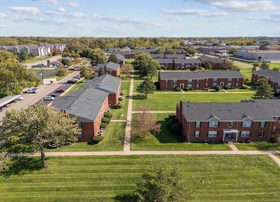 A large grassy area with a few buildings in the distance.