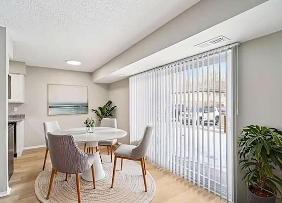 A dining room with a white table and chairs.