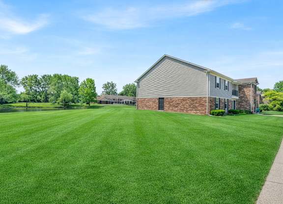 A house with a green lawn in front of it.