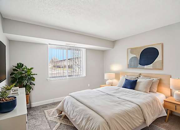 A bedroom with a large bed and a painting on the wall.