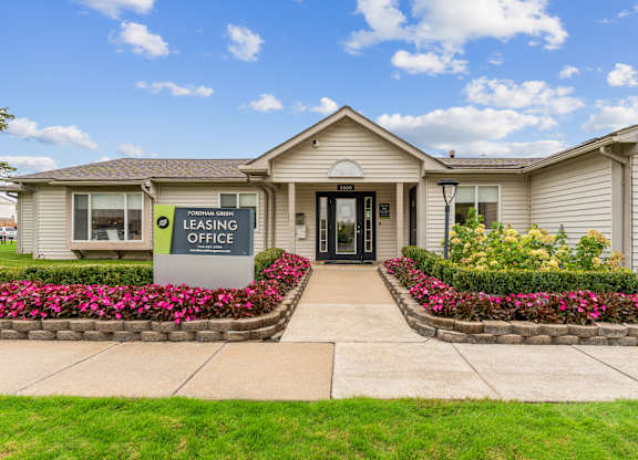 A leasing office is located in a building with a landscaped front yard.