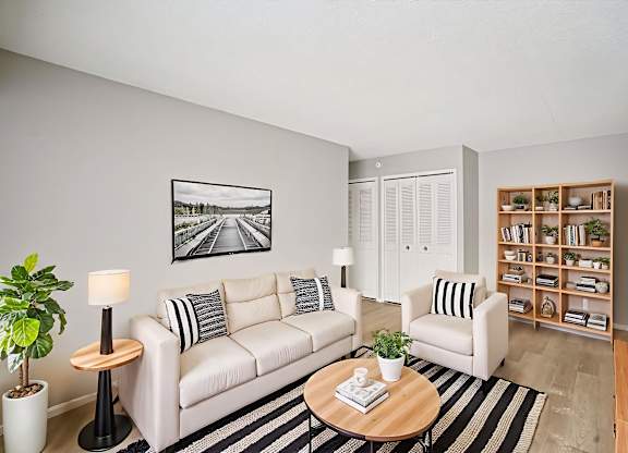 A living room with a white couch, a coffee table, and a bookshelf.