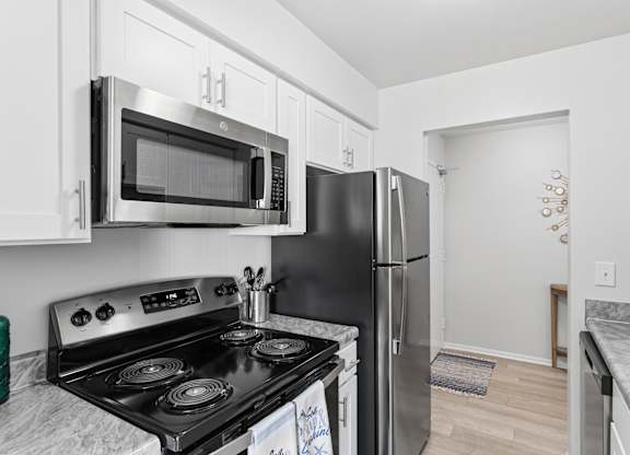 A kitchen with a black stove top oven and a black refrigerator.