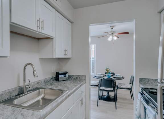 A kitchen with a marble countertop and a ceiling fan.