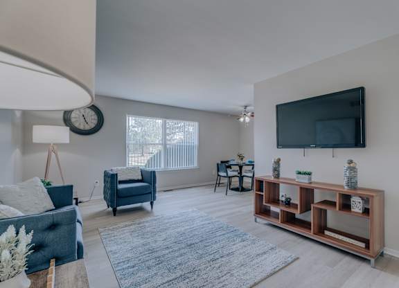 A living room with a blue couch and a wooden shelf.