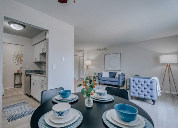 A dining table set with blue and white dishes and a vase of flowers.