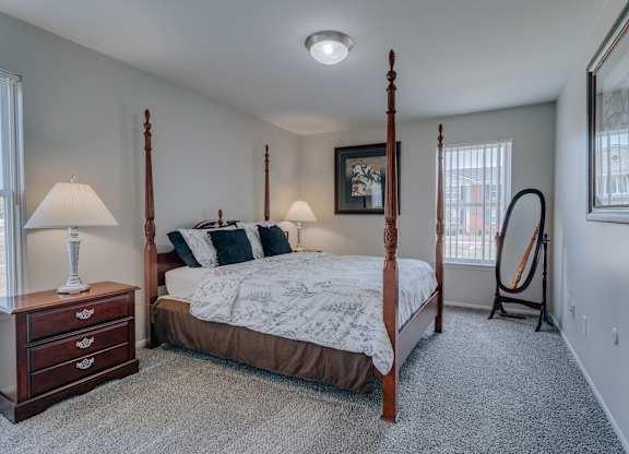 A bedroom with a four poster bed and a window.