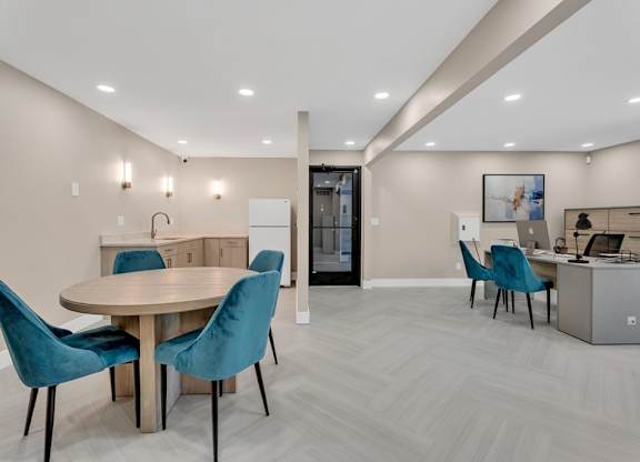 A modern dining room with a round table and blue chairs.