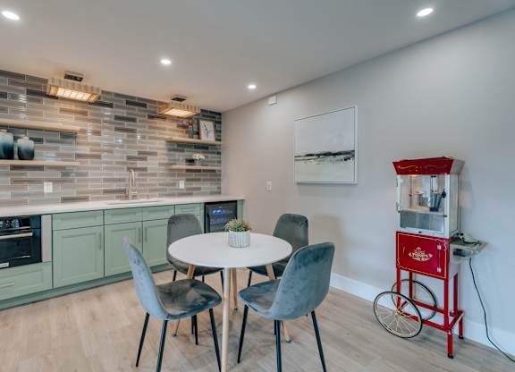 A kitchen with a table and chairs and a red cart.