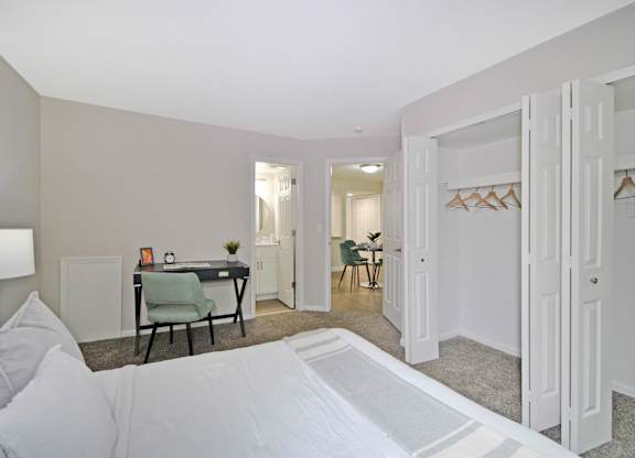 A bedroom with a bed, desk, and chair.