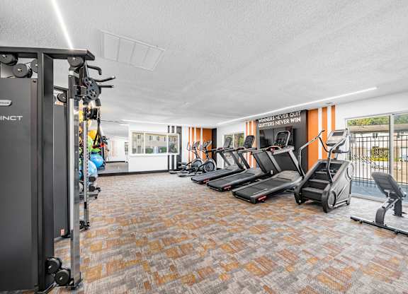 A gym with treadmills, weights, and exercise equipment.
